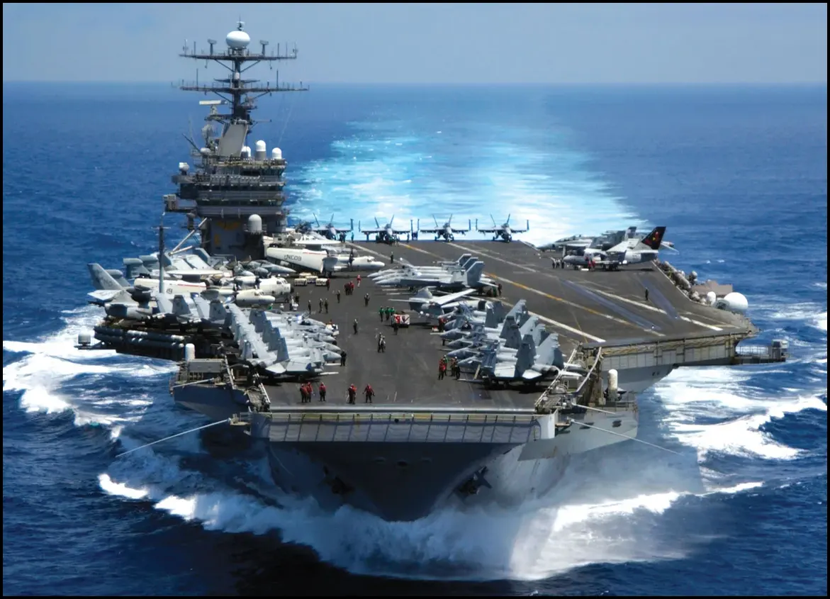 U.S. aircraft carrier underway at sea with aircraft and flight deck crew