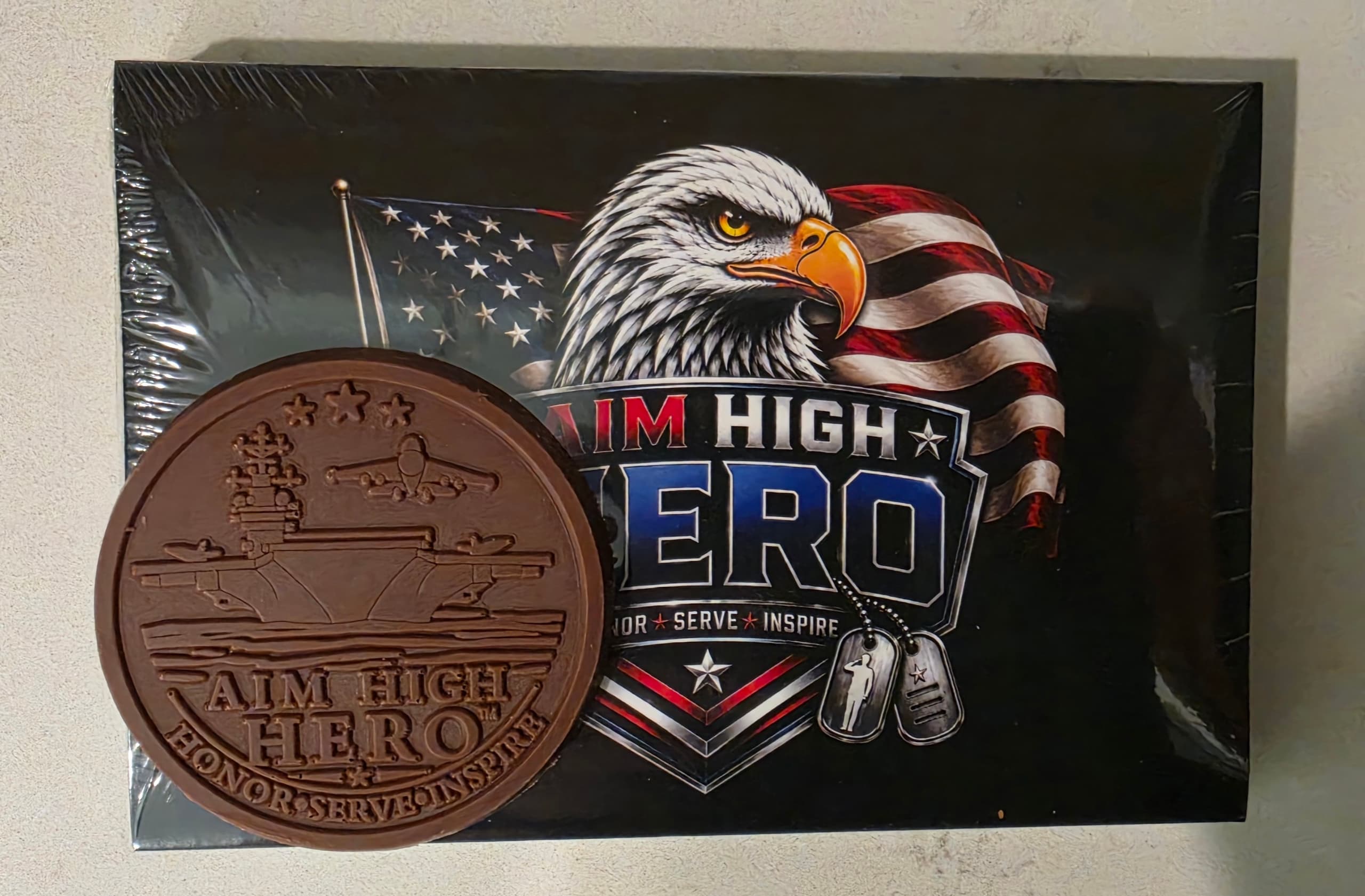 Actual aircraft carrier chocolate coin displayed with its Aim High Hero box