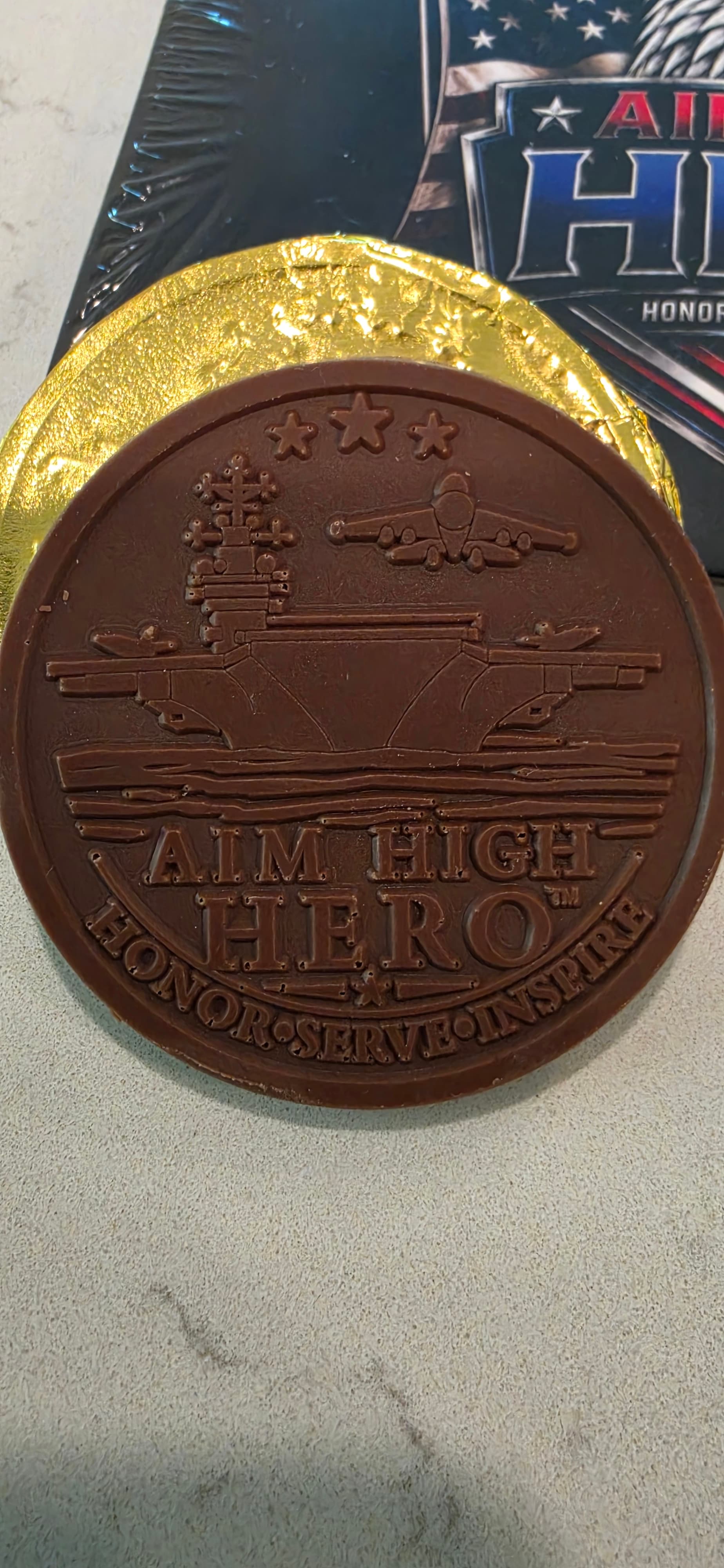 The same carrier chocolate coin with its gold foil wrapper