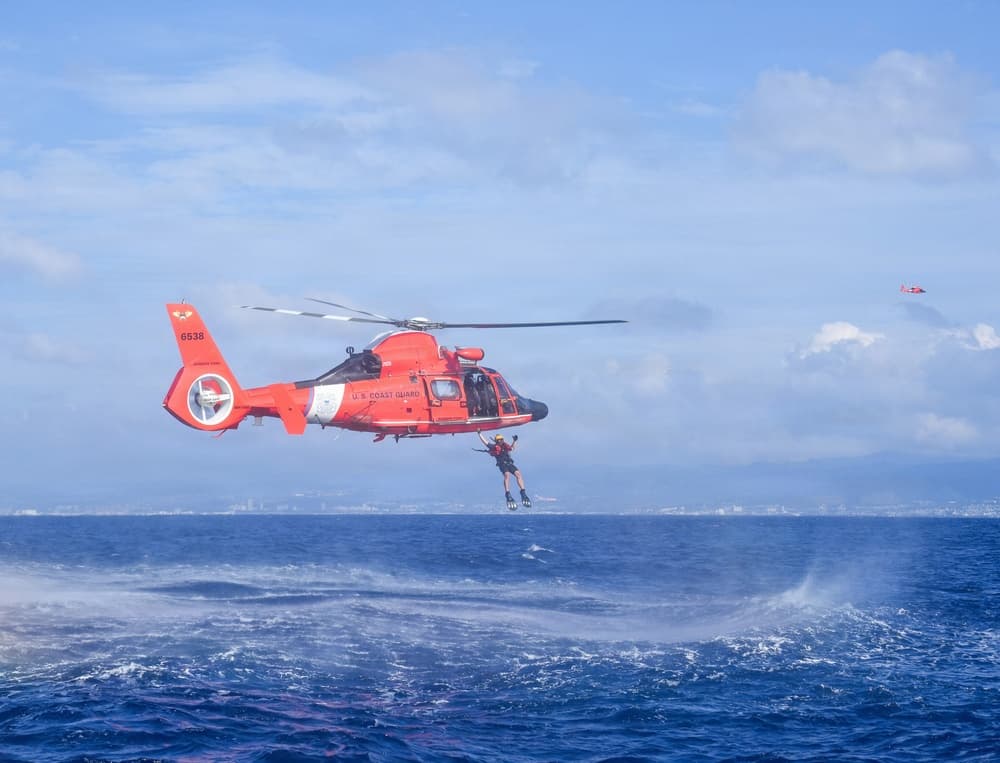 Coast Guard rescue swimmer jumping from an MH-65 helicopter off Honolulu during training